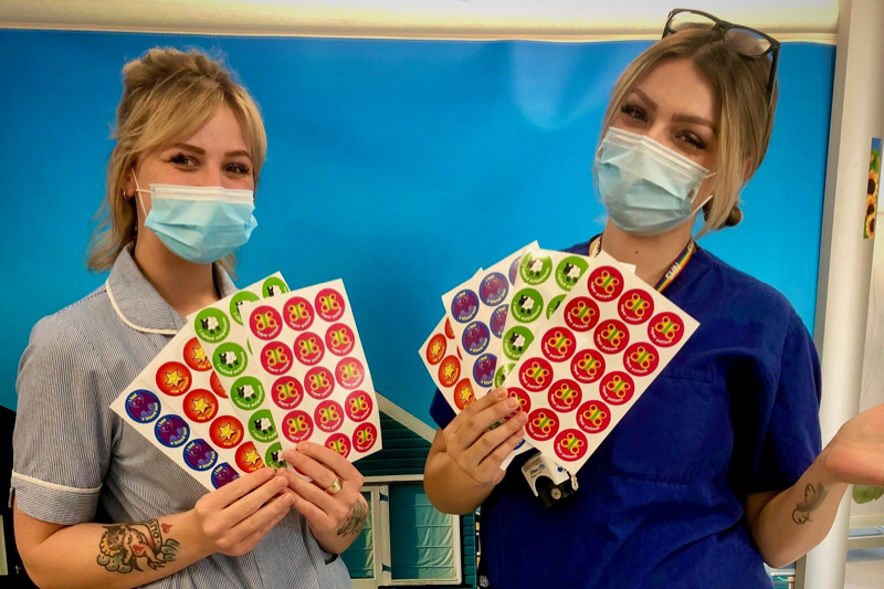 Staff members holding stickers