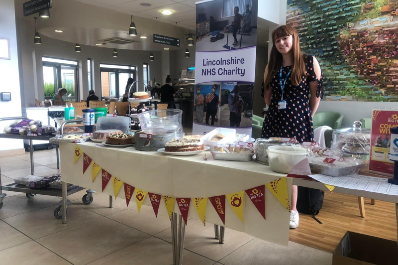 Staff member stood behind table of baked goods