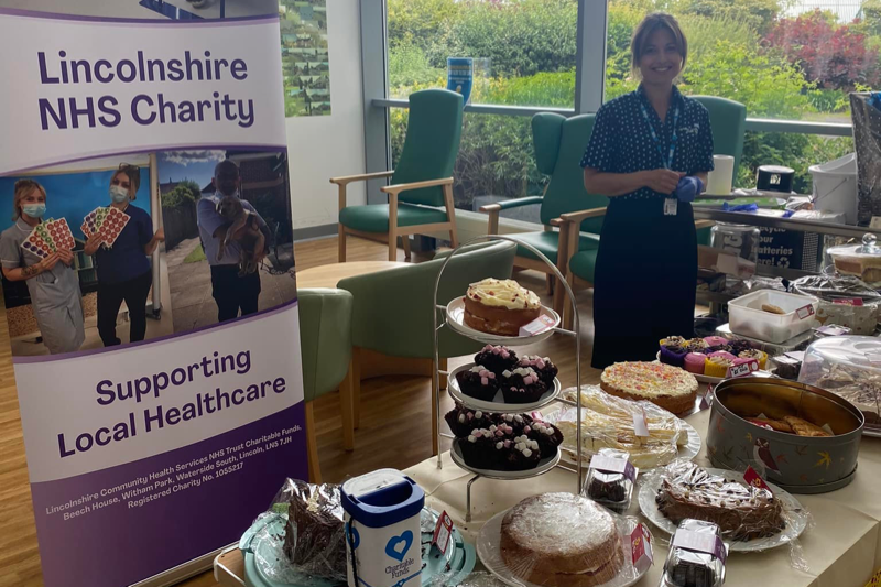 Staff member stood behind table of baked goods