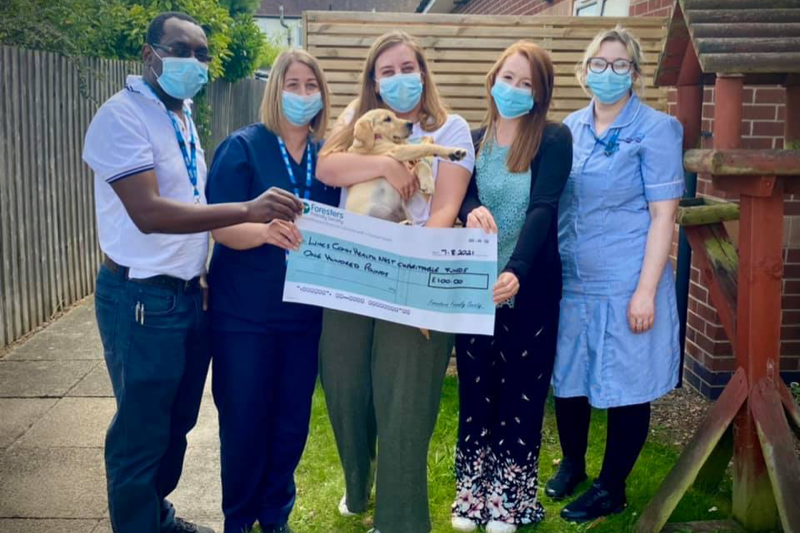Photo of staff and supporters posing with a huge cheque 